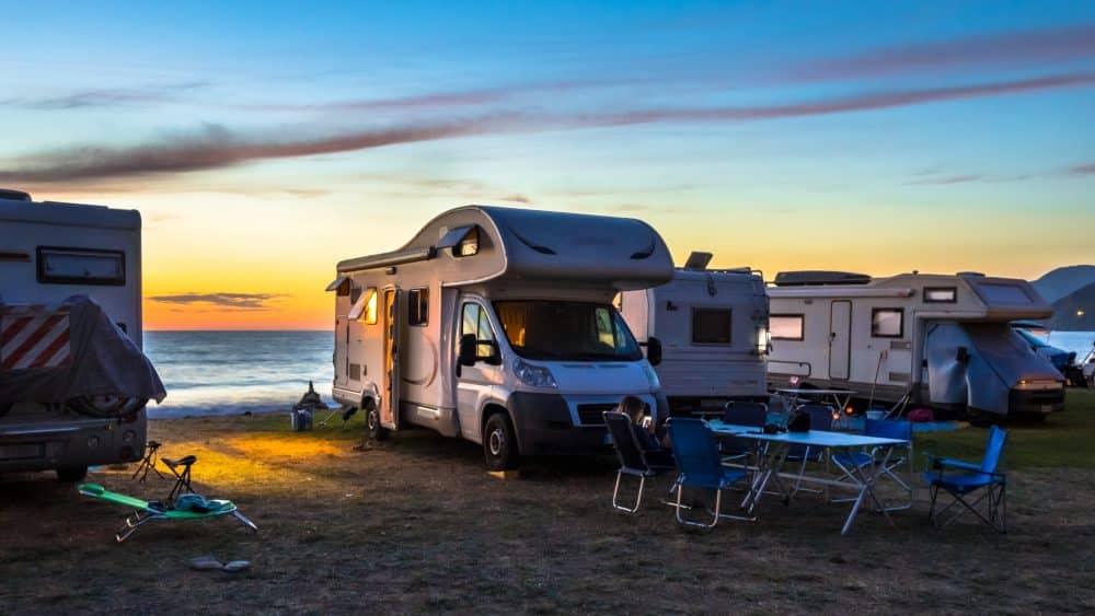 Multiple RVs parked at the beach at sunset