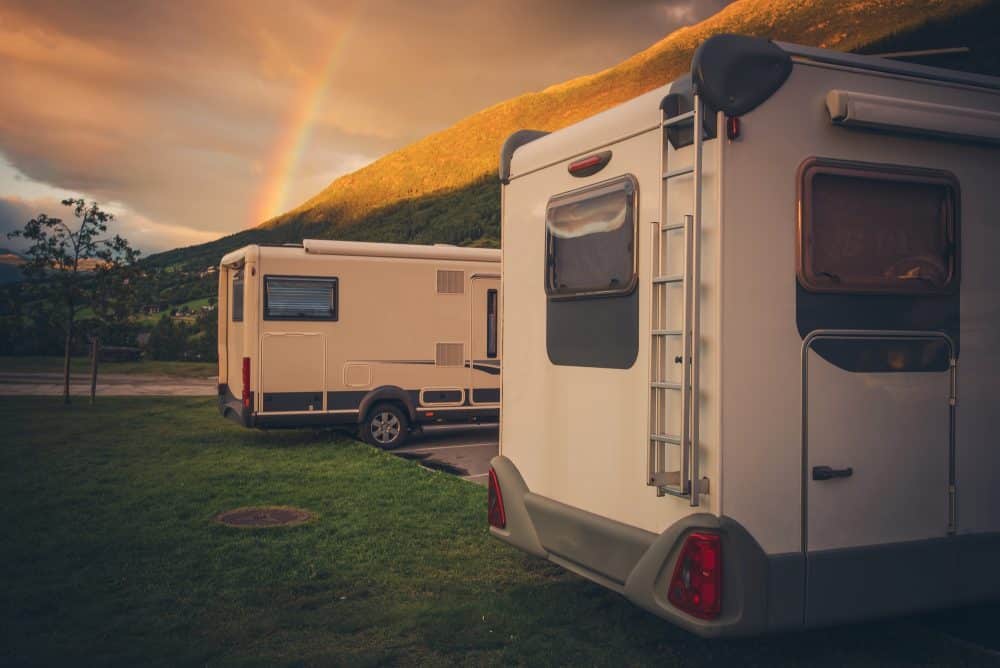 Two RVs parked at a campground at sunset