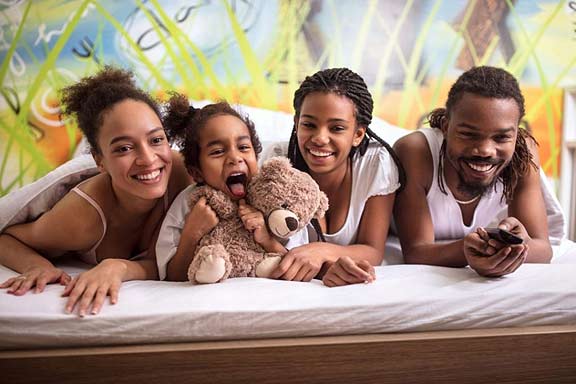 Happy family on sofa bed mattress