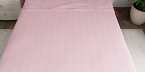 Pink bed sheets on mattress top view